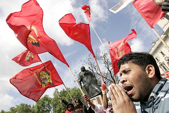 Manifestante pró-tâmeis grita frases de apoio ao lado de bandeiras do movimento separatista em protesto 