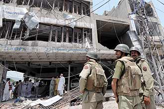 Membros das foras de segurana inspecionam local de atentado suicida com carro-bomba na caidade paquistanesa de Lahore