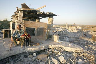 Palestino descansa perto de edificao destruda por ofensiva militar israelense na faixa de Gaza que matou cerca de 1.400 palestinos