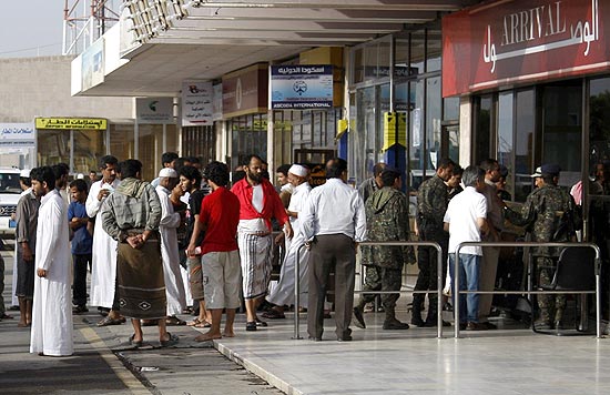 Parentes de passageiros esperam do lado de fora do desembarque no aeroporto internacional de Sanaa (Iêmen) 