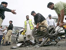 Policiais retiram partes de motocicleta usada em atentado contra um nibus em Rawalpindi