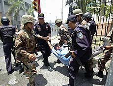 Homem  preso por soldados e policiais em protesto de apoio ao presidente eleito Zelaya