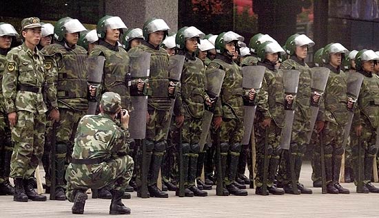 Militar tira foto de soldados chineses que vigiam uma rua de Urumqi; policiais mataram dois uigures a tiros hoje 
