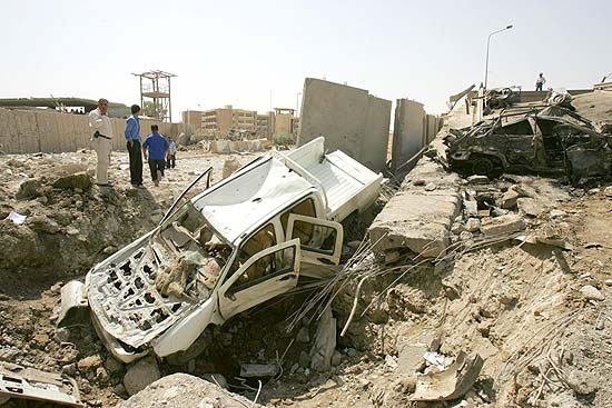 Agentes de segurança iraquianos observam estrago feito por explosão próxima do Ministério das Finanças 