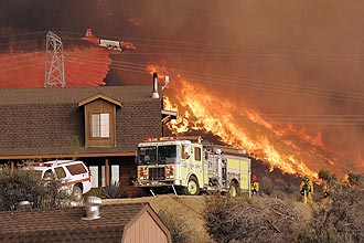 Avião lança água sobre as chamas de incêndio florestal na Califórnia; ao menos dois bombeiros morreram neste domingo