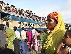 Mulher segura beb no colo em trem na estao de Tongi, no subrbio de Bangladesh