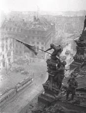 Soldado ergue bandeira sovitica em Berlim aps a derrota nazista