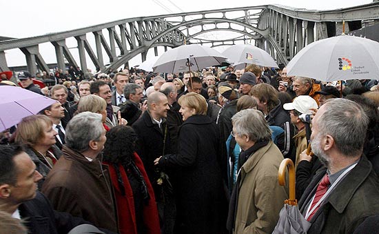 Chanceler alem Angela Merkel cruza simbolicamente a fronteira do Muro de Berlim