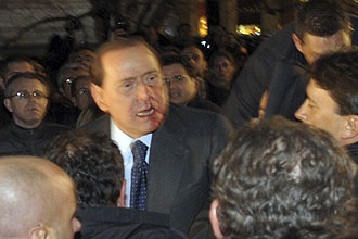 Silvio Berlusconi deixa praa de Milo com o rosto ensanguentado aps ser atingido por uma miniatura atirada por Massimo Tartaglia