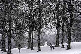 Pessoas caminham por estrada coberta de neve em Edimburgo, na Esccia; nevascas atrapalham milhares de britnicos