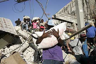 Pessoas saqueiam lojas em região comercial de Porto Príncipe, devastada por tremor; milhares de pessoas morreram na tragédia