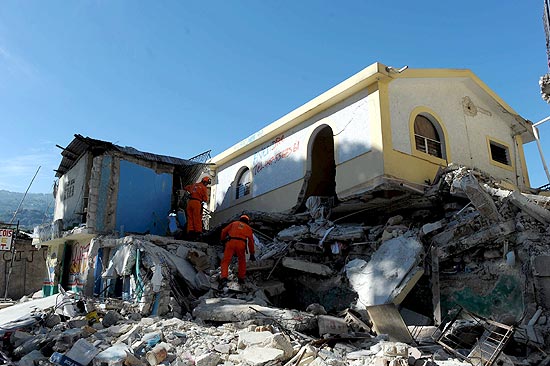 Resgatistas da Holanda procuram sobreviventes entre os escombros, 
em Porto Príncipe; capital foi devastada