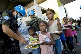 Soldados bolivianos da missão da ONU entregam comida a haitianos 
afetados pelo terremoto que matou milhares