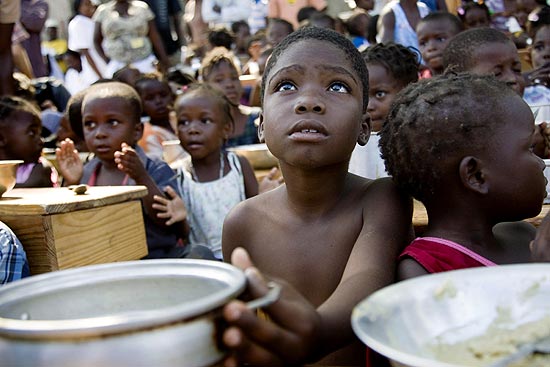 Criança aguarda distribuição de comida no Haiti; pobreza deixa marcas biológicas permanentes nas crianças, dizem cientistas