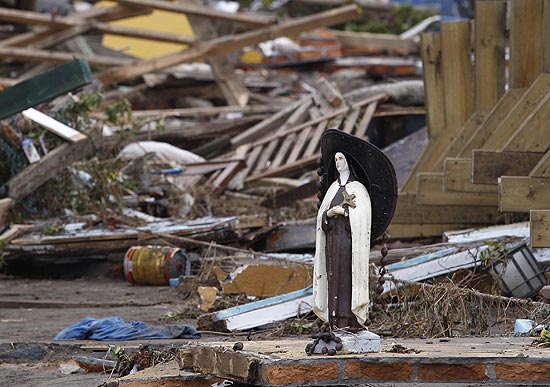 Esttua de Santa Teresa de Lisieux  colocada perto de escombros de prdio destrudo por terremoto 