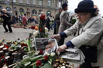 Poloneses se renem em frente ao palcio presidencial em Varsvia para prestar suas homenagens aos mortos no acidente areo