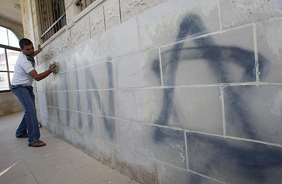 Homem limpa inscrio com o nome de Maom em hebraico e estrela de Davi em mesquita na Cisjordnia 