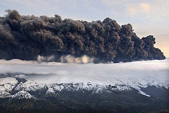 Fumaça do vulcão sob galeira Eyjafjallajokull, na Islândia; erupção impede trânsito aéreo mas é pequena para aliviar mudança clmática