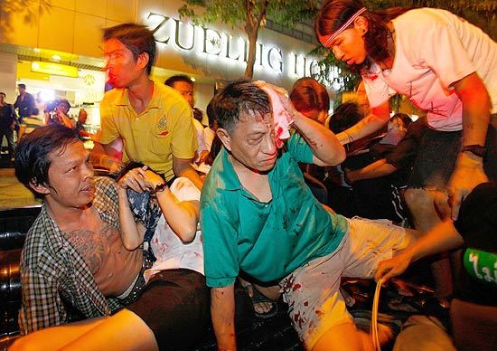 Tailandeses feridos tentam fugir de local de trs exploses em Bancoc, na Tailndia; ao menos dois feridos