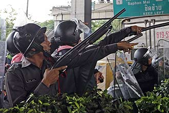 Policiais assumem posição durante confronto com os camisas vermelhas, em Bancoc (Tailândia); ao menos 11 ficaram feridos 