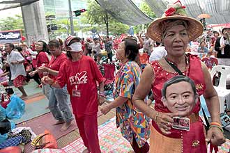Camisas vermelhas danam em acampamento no centro de Bancoc, na Tailndia; eles aceitaram plano do governo para antecipar pleito