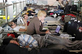 Passageiros dormem enquanto aguardam voo para Helsinki, no aeroporto internacional de Portela; Europa teme caos em pleno vero