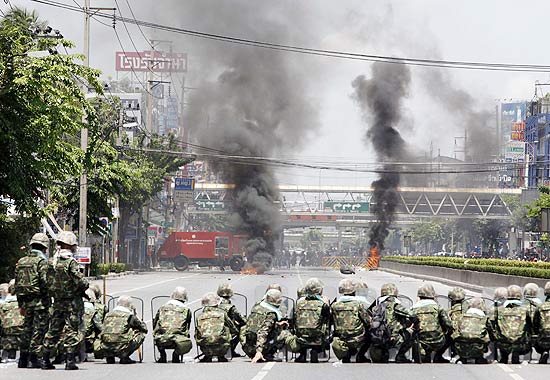 Pneus queimam em meio ao confronto entre as tropas tailandesas e os opositores camisas vermelhas, em Bancoc 