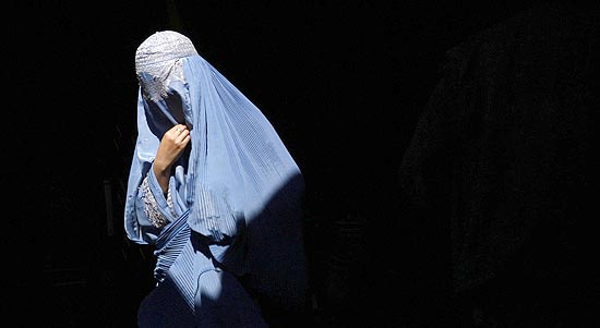 Mulher afeg usa burca, vu que cobre todo o corpo e rosto; vu  comum no pas, mas raro no resto do mundo