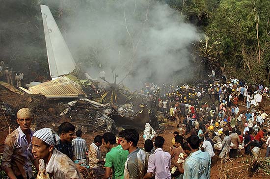 Moradores dos arredores observam fuselagem do avião da Air India Express que saiu da pista e explodiu, em Mangalore