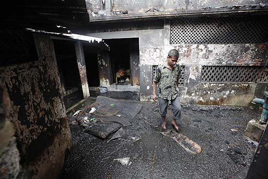 Sobrevivente inspeciona sua casa destruída pelo pior incêndio da história de Bangladesh