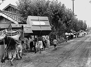Famílias coreanas fogem Yongdong e tentam salvar alguns móveis, foto tirada no dia de 26 de julho de 1950
