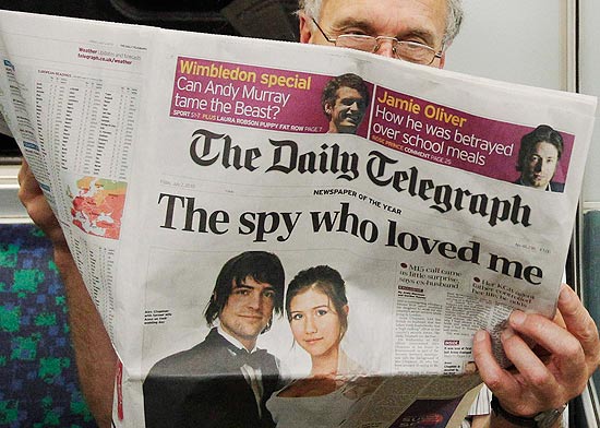 Passageiro l edio de hoje do jornal "Daily Telegraph" que mostra foto do casamento da suposta espio russa