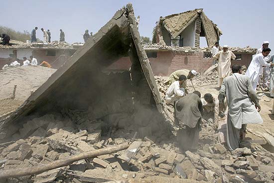 Homens procuram por possíveis sobreviventes sob escombros de edifícios em Mohmand, no noroeste do Paquistão 