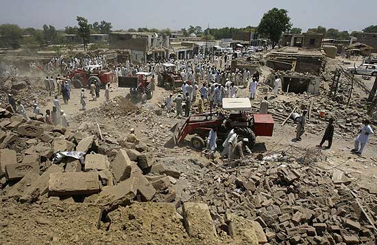 Tratores removem escombros de lojas e casas destrudas por exploso no Paquisto; ao menos 50 morreram 