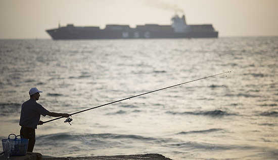 Pescador próximo de porto de Ashdod, em Israel; apesar de ordem de desvio, navio líbio se aproxima de Gaza