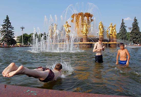 Garotos russos se refrescam em fonte em Moscou, aps pas registrar temperaturas recordes de mais de 33C