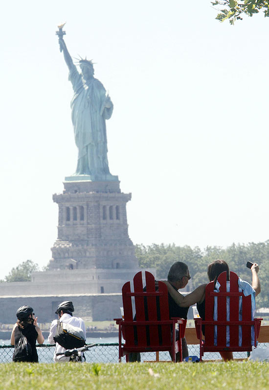 Casal em frente à Estátua da Liberdade, em Nova York