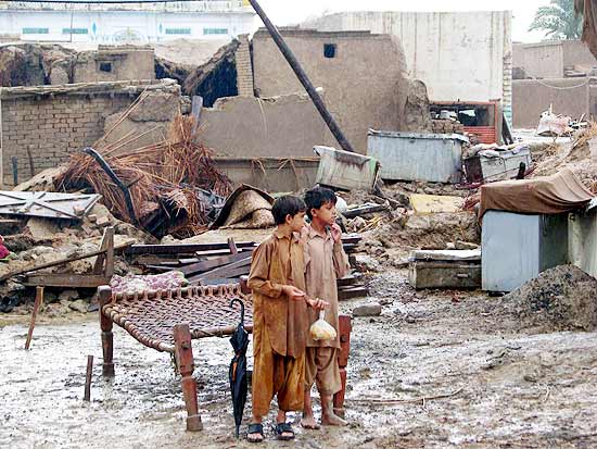 Em Khyber-Pakhtunkhwa, crianças observam casas destruídas pelas chuvas que já afetam 3,2 milhões