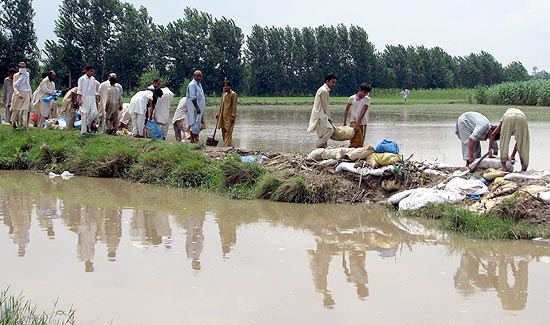 Moradores tentam conter as cheias com barragens improvisadas; cerca de 4,2 milhes foram afetados