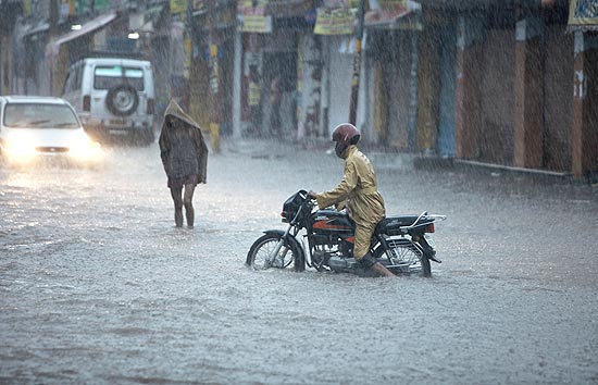 Motociclista passa por rua alagada em Jammu, na ndia; ao menos 88 morreram pelas inundaes 
