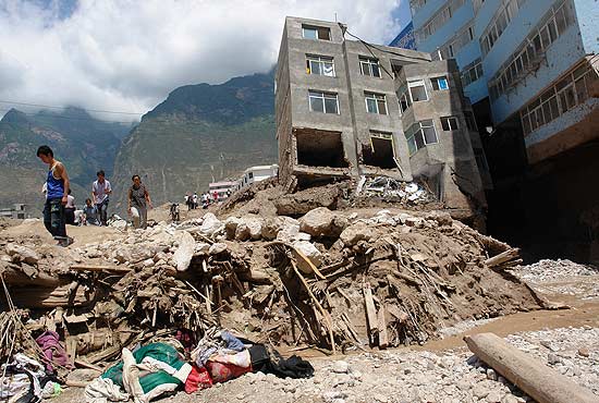 Prédios ficam destruídos após deslizamento de terra e inundações no Condado de Zhouqu, na China
