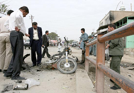Soldados afegos observam danos causados por moto-bomba na cidade de Ghazni, no Afeganisto