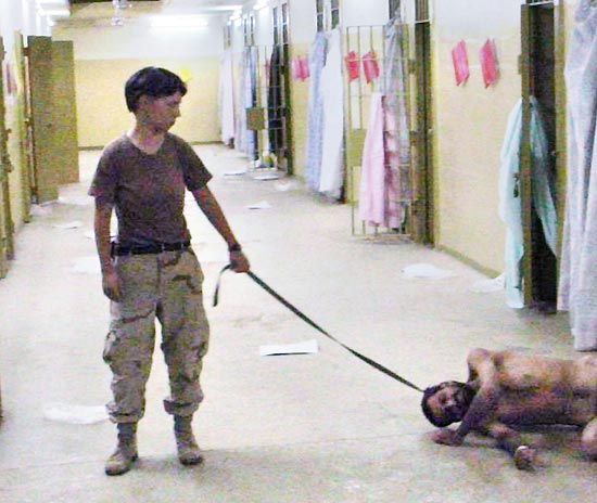 A soldada Lynndie England abusa de presos com coleiras caninas nas imagens vazadas pela imprensa dos EUA