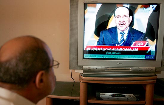 Iraquiano assiste ao discurso em rede nacional do premi Nuri al Maliki