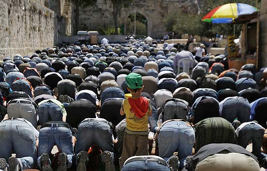 Menino muulmano entre a multido de fieis que oram em Jerusalm durante as celebraes do ltimo dia do Ramad