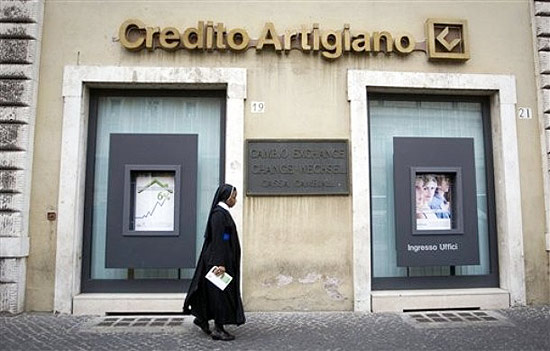 Freira passa em frente a uma agência do Credito Artigiano, banco envolvido nas denúncias contra o Vaticano