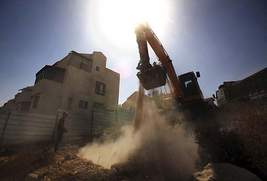 Escavadora remove terra e pedras na retomada das construes em assentamentos judaicos 