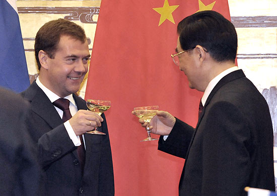 Presidente russo, Dmitri Medvedev (esq.), brinda com colega chins, Hu Jintao, em visita