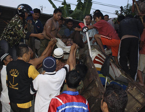Equipes de resgate retiram vtima das ferragens de trem, na Indonsia.