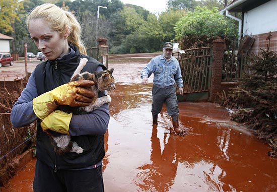 Moradora resgata gato no vilarejo de Devecser, um dos afetados por vazamento txico que j deixou trs mortos
